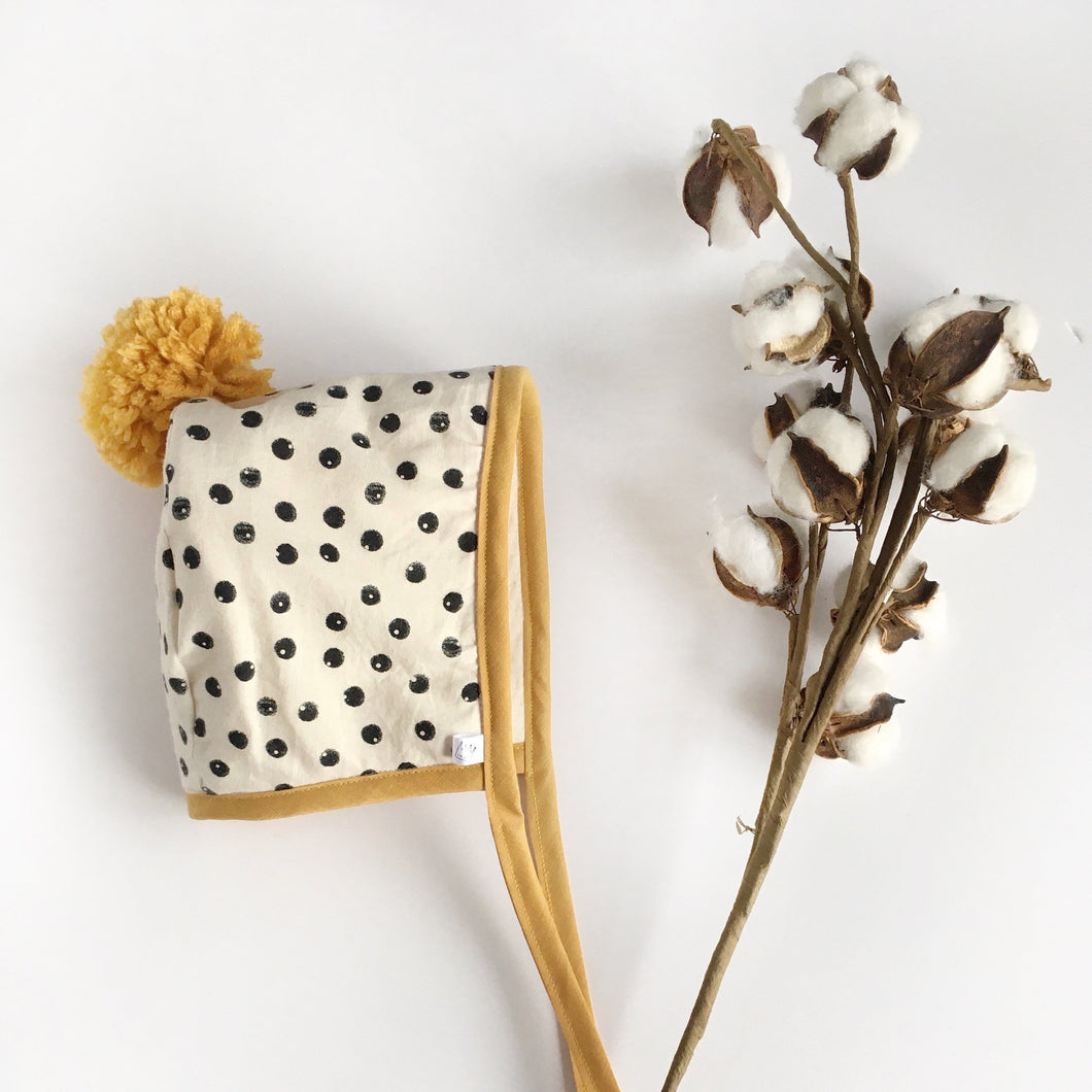 Black and Cream Spotty Winter Bonnet with Mustard Binding and Pom Pom